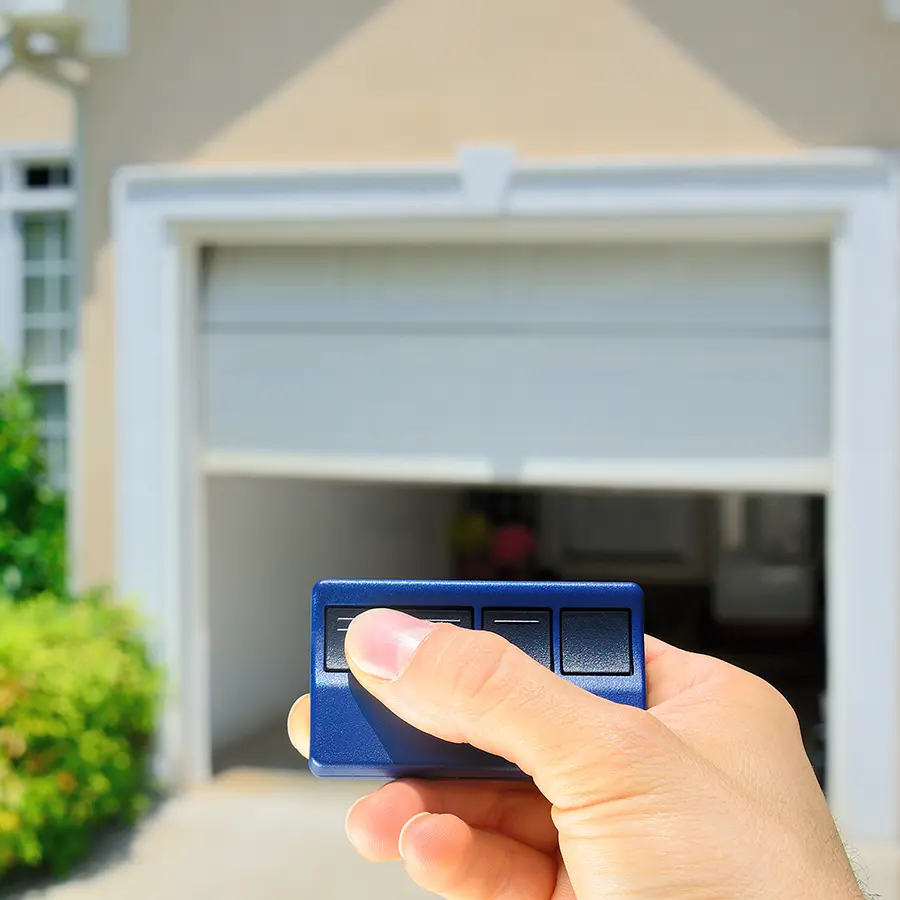 Person pushing button on garage door opener remote