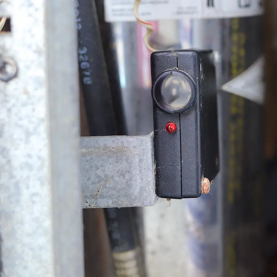 Close up of a garage door photo eye sensor