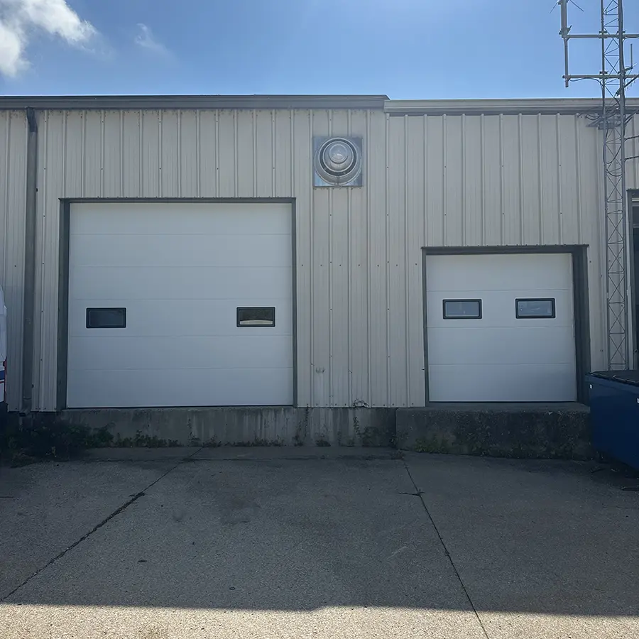 Commercial building with aluminum siding and two large garage doors