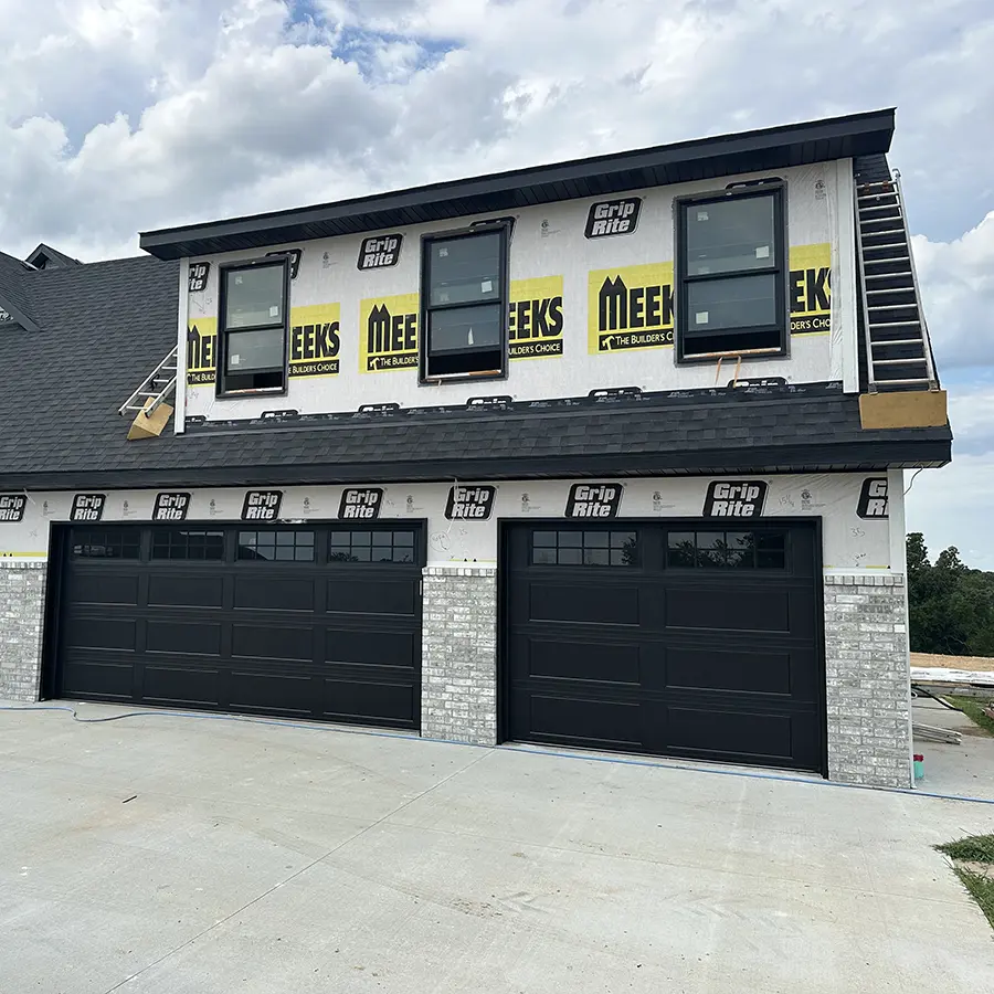 Home under construction with freshly installed garage doors