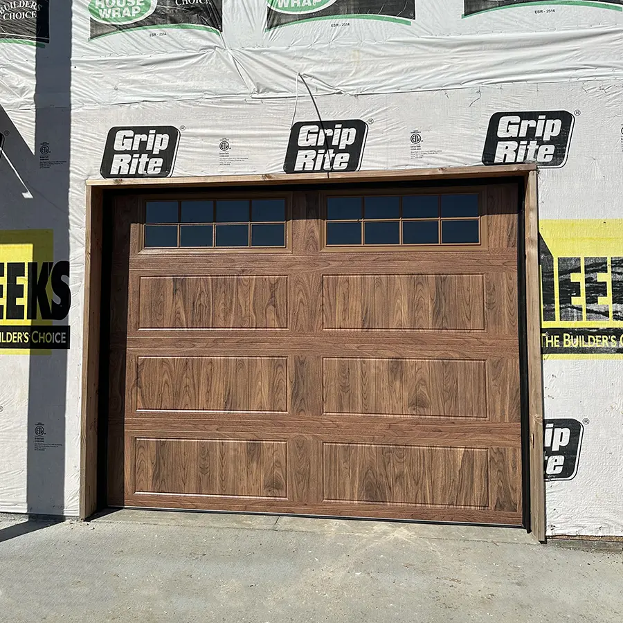 Home under construction with freshly installed brown garage door
